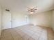 Bedroom featuring tile floor, ceiling fan, and a door that gives access to the outside at 10824 Peppertree Ln, Port Richey, FL 34668