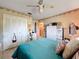 Bright bedroom with blue bed, ceiling fan, and ample closet space for storage at 10824 Peppertree Ln, Port Richey, FL 34668