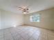 Bedroom featuring tile floor, ceiling fan, and a window providing natural light at 10824 Peppertree Ln, Port Richey, FL 34668