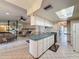 Kitchen with an open floor plan and a kitchen island, tile floors and white cabinets at 10824 Peppertree Ln, Port Richey, FL 34668