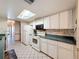 Traditional kitchen with white appliances, ample cabinet space, and tiled floors at 10824 Peppertree Ln, Port Richey, FL 34668