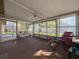 Bright sunroom with ceiling fan and sliding windows overlooking the backyard with a white fence and green grass at 10824 Peppertree Ln, Port Richey, FL 34668