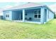A well-maintained lawn surrounds a covered patio in this home's backyard at 13447 Newport Shores Dr, Hudson, FL 34669