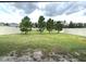 A spacious backyard with trees is enclosed by a white vinyl privacy fence at 13447 Newport Shores Dr, Hudson, FL 34669