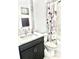 Well-lit bathroom featuring a single sink vanity, and shower-tub combo with decorative shower curtain at 13447 Newport Shores Dr, Hudson, FL 34669