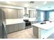 Modern kitchen featuring stainless appliances, island with sink and gray cabinetry at 13447 Newport Shores Dr, Hudson, FL 34669