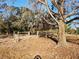 Fenced backyard with mature trees and a gate at 15645 Olney Ln, Spring Hill, FL 34610