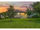 House exterior view at sunset with a grassy backyard at 19504 Lily Pond St, Brooksville, FL 34601