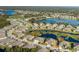 Aerial view of a community with houses and a large pond at 13335 Crest Lake Dr, Hudson, FL 34669