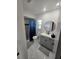 Modern bathroom with gray vanity, marble-look floors, and a shower/tub combo at 10234 Bedford Rd, Spring Hill, FL 34608