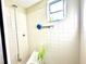 Clean bathroom featuring tiled walls, a walk-in shower, and a window for natural light at 10521 Mira Vista Dr, Port Richey, FL 34668
