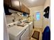 Functional laundry room with appliances, storage shelves, and access to the outdoors at 10521 Mira Vista Dr, Port Richey, FL 34668