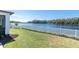 Beautiful backyard view showcasing the white picket fence bordering a tranquil lake and lush landscaping at 12135 Crestridge Loop, Trinity, FL 34655