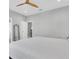 Main bedroom showcasing a neutral color scheme, ceiling fan, and a glimpse into the ensuite bathroom at 12135 Crestridge Loop, Trinity, FL 34655