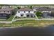 Rear exterior of the home showing white picket fence, lush green lawn and lake view at 12135 Crestridge Loop, Trinity, FL 34655