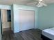 Bright bedroom featuring modern ceiling fan, closet and sleek wood-look flooring at 3018 Greynolds Ave, Spring Hill, FL 34608