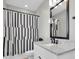 Chic bathroom featuring a black and white shower curtain and modern vanity, maximizing space and style at 6120 Marsh Trail Dr, Odessa, FL 33556