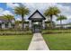 Welcoming community entrance with a gated walkway, lush greenery, and mature palm trees at 6120 Marsh Trail Dr, Odessa, FL 33556