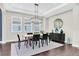 Bright dining room with modern light fixture, stylish rug, and ample natural light from large windows at 6120 Marsh Trail Dr, Odessa, FL 33556