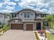 Beautiful two-story home with a three-car garage and a brick paved driveway and a well-manicured lawn at 6120 Marsh Trail Dr, Odessa, FL 33556