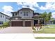 Charming two-story home with stone accents, a three-car garage, and lush landscaping with palm trees at 6120 Marsh Trail Dr, Odessa, FL 33556
