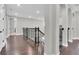 Spacious upstairs hallway with dark hardwood floors, arched doorways, and wrought iron railings at 6120 Marsh Trail Dr, Odessa, FL 33556