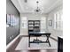 Well-lit home office featuring a modern desk, shelving unit, and a contemporary light fixture at 6120 Marsh Trail Dr, Odessa, FL 33556