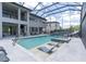 The screened-in pool features in-pool lounge chairs, a slide and a built in hot tub at 6120 Marsh Trail Dr, Odessa, FL 33556