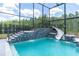 Stunning enclosed pool featuring a water slide, waterfall, and lush greenery, perfect for relaxing or entertaining guests at 6120 Marsh Trail Dr, Odessa, FL 33556
