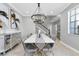 Bright dining room showcasing a white table, gray chairs, and a stunning chandelier at 12135 Crestridge Loop, Trinity, FL 34655