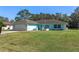 Charming light blue house with a spacious lawn and attached garage at 3018 Greynolds Ave, Spring Hill, FL 34608
