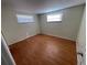 Well-lit bedroom with wood-look floors and two windows at 5319 Whippoorwill Dr, Holiday, FL 34690