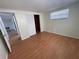 Spacious bedroom featuring wood-look floors and a large closet at 5319 Whippoorwill Dr, Holiday, FL 34690