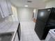 Kitchen with black appliances and view into adjacent rooms at 5319 Whippoorwill Dr, Holiday, FL 34690