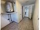 Laundry room with tile floor, storage and access to kitchen at 5319 Whippoorwill Dr, Holiday, FL 34690