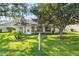 House with backyard, lush green grass, and large trees at 6424 Lost Tree Ln, Spring Hill, FL 34606