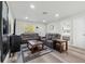 Bright living room features two leather sofas, a coffee table, and wood-look flooring at 5110 Colchester Ave, Spring Hill, FL 34608