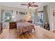 Bright bedroom with hardwood floors, a ceiling fan, and backyard views at 13517 Hunters Point St, Spring Hill, FL 34609