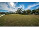 Expansive green space with well-maintained grass and lush trees under a bright sky at 10595 Marsha Dr, New Port Richey, FL 34655