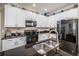 Bright kitchen featuring granite counters, white cabinets, and modern stainless steel appliances at 10595 Marsha Dr, New Port Richey, FL 34655