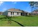 Large backyard with a well-maintained lawn, complemented by the home's neutral exterior at 19364 Sheltered Hill Dr, Brooksville, FL 34601