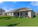 Backyard showcasing a lush green lawn and the home's covered patio at 19364 Sheltered Hill Dr, Brooksville, FL 34601