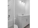 Well-lit bathroom with a white vanity, tub with tile surround and a white toilet at 19364 Sheltered Hill Dr, Brooksville, FL 34601