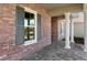A close up shot of a home's red brick exterior with white columns and gray shutters at 19364 Sheltered Hill Dr, Brooksville, FL 34601