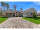Charming single-story home featuring a brick facade, gray shutters, and a patterned brick driveway at 19364 Sheltered Hill Dr, Brooksville, FL 34601