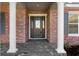 Inviting entryway with decorative glass door, brick accents, and classic white columns at 19364 Sheltered Hill Dr, Brooksville, FL 34601