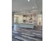 Spacious kitchen featuring white cabinetry, a center island, stainless steel appliances, and wood-style flooring at 19364 Sheltered Hill Dr, Brooksville, FL 34601