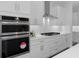 Modern stainless-steel oven, microwave, and gas cooktop complementing white cabinetry and subway tile at 19364 Sheltered Hill Dr, Brooksville, FL 34601