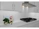 Close-up of modern white kitchen countertop with gas cooktop and subway tile backsplash at 19364 Sheltered Hill Dr, Brooksville, FL 34601