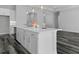 Open kitchen featuring a large island with bar seating, stainless steel appliances, and sleek, gray plank flooring at 19364 Sheltered Hill Dr, Brooksville, FL 34601